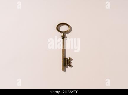 Retro brass keys set against a beige background. View from directly above. Stock Photo