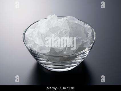rock candy in a glass bowl set against a black background. Stock Photo