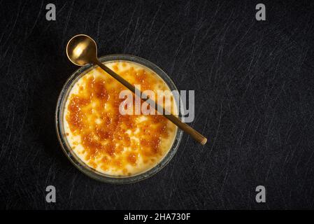 French vanilla cream desert with cinnamon in a bowl top view on dark table Stock Photo