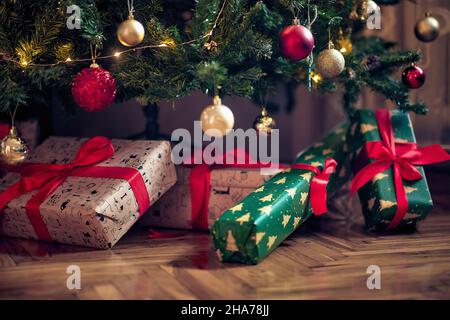 Wrapped christmas presents under the tree on a Christmas evening Stock Photo