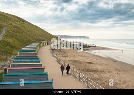 colourful row of  beach huts on the seafront in Whitby North Yorkshire UK Stock Photo