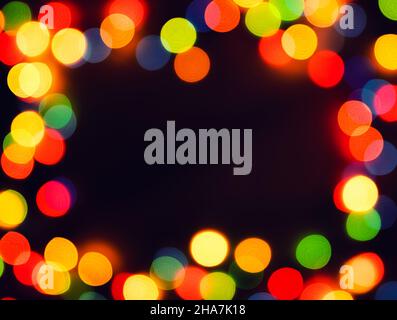 Blurred christmas lights frame on dark background Stock Photo