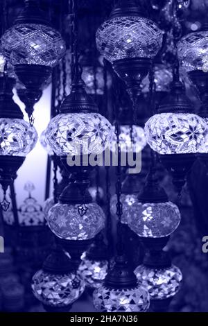 Traditional vintage Turkish lamps over light background in the night. Color of 2022 year, very peri, toed Stock Photo