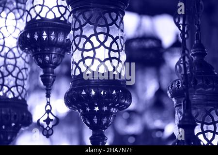 Traditional vintage Turkish lamps over light background in the night. Color of 2022 year, very peri, violet Stock Photo