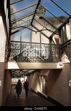 UK, Cumbria, Allerdale, Keswick, shoppers in covered entrance to Packhorse Yard shopping square Stock Photo