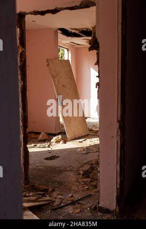 Scary empty dark corridor in an abandoned building. Shabby walls. The play of light and shadows in an abandoned house. Broken doors. An old abandoned Stock Photo