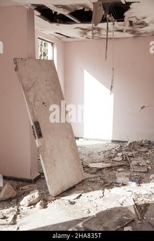 Scary empty dark corridor in an abandoned building. Shabby walls. The play of light and shadows in an abandoned house. Broken doors. An old abandoned Stock Photo