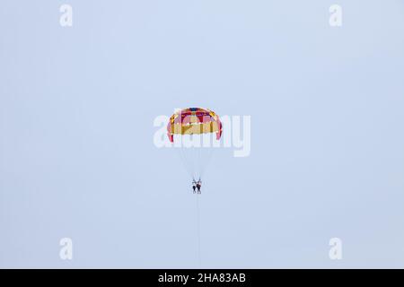 Tourists fly over the sea and the beach on a parachute. Sport and recreation for tourists in turkey. Stock Photo