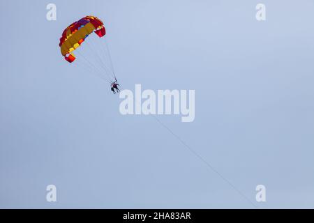 Tourists fly over the sea and the beach on a parachute. Sport and recreation for tourists in turkey. Stock Photo