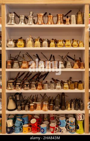 Kemer, Turkey - 08. 31. 2021: inside of shop selling traditional turkish coffee pots, hanging copper pots, various cezve on sale, close up, low angle Stock Photo