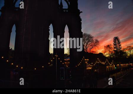 Sunset over Scott monument and big wheel in Edinburgh with the Christmas market Stock Photo
