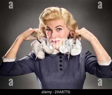 1950s PORTRAIT BLOND WOMAN HOLDING UP A PAIR OF BABY BOOTIES IN EACH HAND LOOKING AT CAMERA - g4280c DEB001 HARS MOTHERS OLD TIME NOSTALGIA OLD FASHION 1 STYLE BLOND PLEASED FAMILIES JOY LIFESTYLE PARENTING CELEBRATION FEMALES STUDIO SHOT GROWNUP HEALTHINESS HOME LIFE COPY SPACE LADIES PERSONS CARING EYE CONTACT PREGNANT MATERNAL DREAMS HAPPINESS HEAD AND SHOULDERS BOOTIES EXCITEMENT PRIDE UP SMILES JOYFUL DEB001 EXPECTING GROWTH MID-ADULT MID-ADULT WOMAN MOMS PARENTAL PARENTHOOD YOUNGSTER BABY SHOES CAUCASIAN ETHNICITY OLD FASHIONED Stock Photo