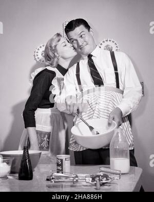 https://l450v.alamy.com/450v/2ha886h/1950s-wife-kissing-her-husband-on-the-check-as-he-mixes-batter-cooks-in-the-kitchen-both-wearing-aprons-h2822-deb001-hars-suburban-urban-her-expression-old-time-nostalgia-old-fashion-1-silly-facial-style-comic-teamwork-neck-strong-pleased-joy-lifestyle-satisfaction-females-married-studio-shot-spouse-husbands-home-life-copy-space-friendship-half-length-ladies-persons-inspiration-caring-males-ingredients-expressions-aprons-bw-partner-batter-homemaker-dreams-humorous-happiness-homemakers-cheerful-comical-white-shirt-housewives-necktie-smiles-suspenders-connection-comedy-cooks-joyful-support-2ha886h.jpg