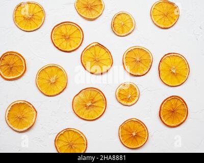 Dehydrated crispy fruits for decorating dishes for drinks and desserts. Dried orange slices or chips on white background. Heap, pile of sun dried Stock Photo