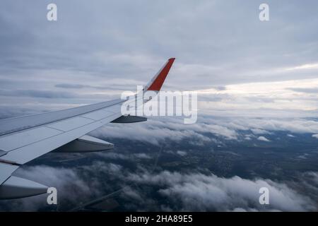 Classic image through aircraft window onto wing. Flight view over clouds Stock Photo