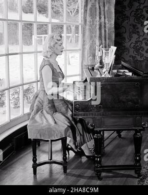 1950s 1960s BLONDE WOMAN PLAYING GRAND PIANO IN FRONT OF LARGE BAY WINDOW  - m2070 DEB001 HARS SOUND SATISFACTION MUSICIAN FEMALES BAY HOME LIFE LUXURY SEATED COPY SPACE HALF-LENGTH LADIES PERSONS B&W WINTERTIME SKILL ACTIVITY AMUSEMENT HOBBY INTEREST HOBBIES KNOWLEDGE PASTIME PLEASURE OCCUPATIONS UPSCALE MUSICAL INSTRUMENT AFFLUENT STYLISH DEB001 GRAND PIANO WINTERY CREATIVITY MID-ADULT MID-ADULT WOMAN PIANIST RELAXATION WELL-TO-DO AMATEUR BLACK AND WHITE CAUCASIAN ETHNICITY ENJOYMENT HIGH HEELS OLD FASHIONED PRACTICING Stock Photo