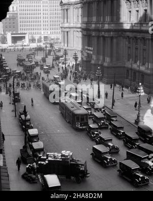 1920s 1930s TROLLEYS CARS TRUCKS TRAFFIC AROUND EAST SIDE OF CITY HALL LOOKING SOUTH PHILADELPHIA PENNSYLVANIA USA - p2547 HAR001 HARS HIGH ANGLE AUTOS EXTERIOR PA TROLLEY COMMONWEALTH AUTOMOBILES CITIES KEYSTONE STATE TROLLEYS VEHICLES STREETCARS TROLLEY BUS BLACK AND WHITE CITY OF BROTHERLY LOVE HAR001 OLD FASHIONED PUBLIC TRANSPORTATION STREETCAR TRAM TROLLEY CAR Stock Photo