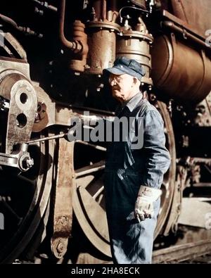 1920s OLDER MAN RAILROAD LOCOMOTIVE ENGINEER OILING MOVING DRIVER CONNECTING RODS ON STEAM ENGINE BEFORE BEGINNING THE WORK DAY - r7781c HAR001 HARS SPEED SATISFACTION JOBS RURAL COPY SPACE HALF-LENGTH PERSONS MALES CONFIDENCE TRANSPORTATION MIDDLE-AGED MIDDLE-AGED MAN RAIL BEFORE OCCUPATION PROTECTION STRENGTH KNOWLEDGE POWERFUL LABOR PRIDE AUTHORITY EMPLOYMENT LOCOMOTIVE OCCUPATIONS CONNECTION MAINTENANCE CONCEPTUAL MAINTAIN STYLISH CONNECTING RAILROADS EMPLOYEE OILING PRECISION RODS BEGINNING CAUCASIAN ETHNICITY HAR001 LABORING OLD FASHIONED WORK CLOTHES Stock Photo