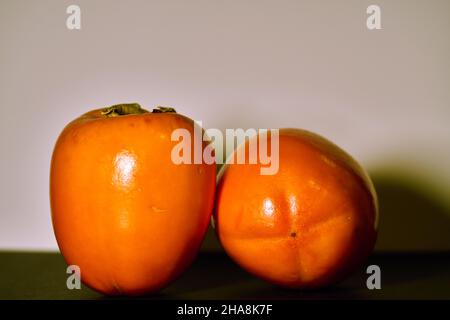 Two ripe persimmons for a healthy meal Stock Photo