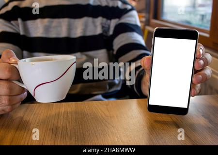 Man's hand holding smartphone, mockup image of hand showing mobile phone with blank white screen. Stock Photo