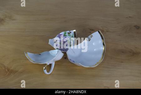 Broken cup in wooden background. Concept. Stock Photo