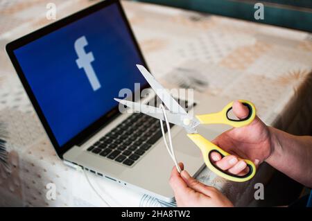 scissors cuts power to facebook Stock Photo