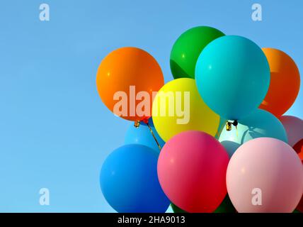 bunch of multicolored balloons in the city festival on clear blue sky background Stock Photo