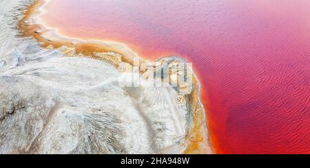 Mining of ores of various metals. Red toxic water in the reservoir of the mining and processing plant. Drone view. Stock Photo