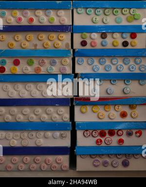 Button boxes in the haberdashery shop.  There are colorful buttons on the boxes.  Buttons are used for textile and hobby purposes. Stock Photo