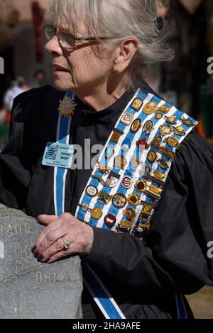 A member of the Daughters of the American Revolution wears her DAR pins, ribbons and sash at a commemorative event in Santa Fe, New Mexico. Stock Photo