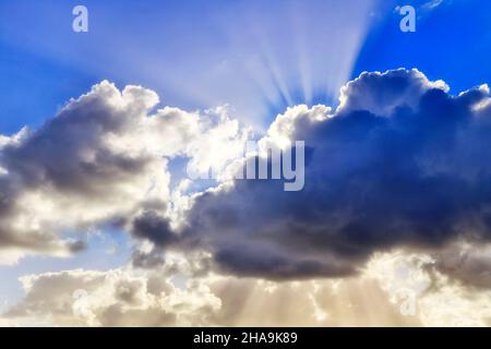 Storm clouds covering sun disk blocking sun light over Pacific ocean off Australian coast in windy weather. Stock Photo