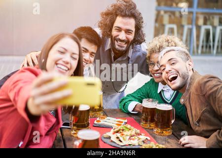 Diverse group of friends taking a selfie at a outdoors party. Stock Photo