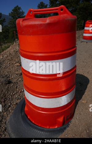 Bright orange traffic barrel with reflective stripes Stock Photo