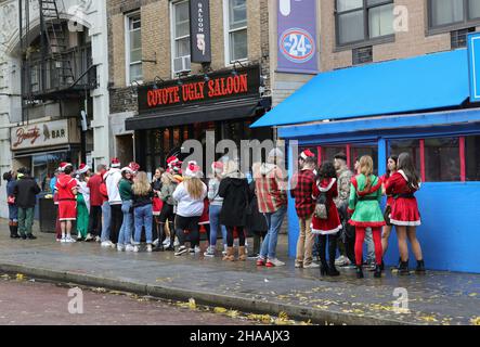 East Village, New York, USA, December 11th, 2021 - Several thousand Santas roamed the streets of the East Village in New York City celebrating Santacon 2021. SantaCon the annual mass gathering of people dress in Santa Claus costumes to do a one day bar hopping all over New York Pubs. Coyote Ugly Girls Dancing on the Bar Like the Movie. Photos by: Luiz Rampelotto/EuropaNewswire PHOTO CREDIT MANDATORY. Stock Photo