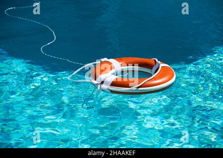 Preserver lifebuoy. Orange lifebuoy in sea on water. Life ring floating of water. Stock Photo