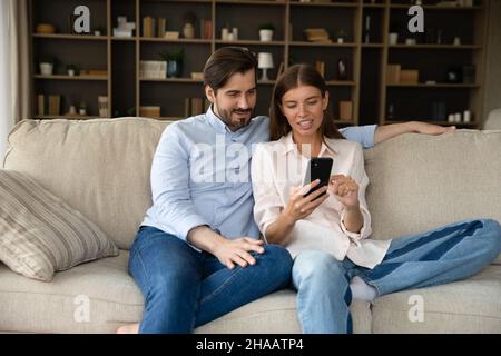 Happy millennial couple using online shopping app Stock Photo
