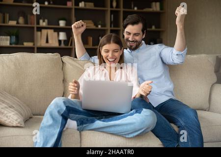 Happy shocked young couple getting exciting good news Stock Photo