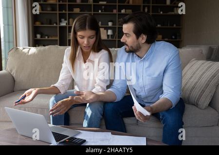 Worried concerned young couple doing paperwork at home Stock Photo