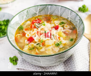 Minestrone, italian vegetable soup with pasta on light table. Stock Photo