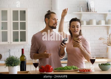 Excited young dating couple having fun in kitchen Stock Photo