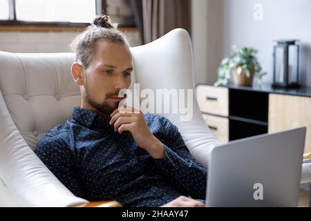 Focused millennial freelance worker, business man working at laptop Stock Photo