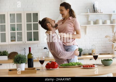 Excited couple in love enjoying funny leisure time in kitchen Stock Photo