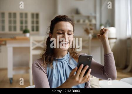 Happy surprised smartphone user receiving amazing good news on smartphone Stock Photo