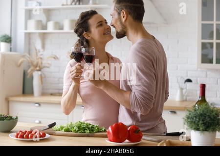 Sweet romantic millennial couple dating at home, drinking wine Stock Photo
