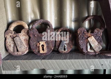 A row of four old rusty padlocks Stock Photo