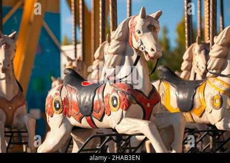 Merry-go-round wooden horses at amusement park. Vintage carousel pony at luna park. Stock Photo