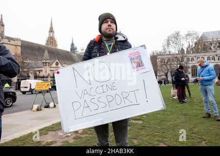 A protestor seen holding a placard that says 'No vaccine passport!' during the demonstration.Jointly led by Big Brother Watch and Migrant Organise, protestors gathered to voice discontent in relation to the UK government's attempt to make vaccine passports and other forms of COVID IDs a requisite for large scale events and entry into public spaces. The group seeks to clearly delineate the difference between anti vaccine passports specifically and anti vaccines, with which they identify with the former. (Photo by Belinda Jiao/SOPA Images/Sipa USA) Stock Photo