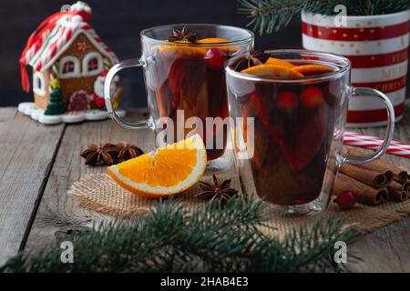 Christmas mulled red wine with spices and oranges on a wooden rustic table.  Stock Photo