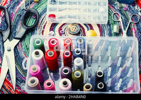 Multicolor threads, needles, buttons and seamstress instrument. Sewing accessories Stock Photo