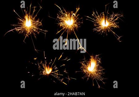 set of burning chrismas sparklers isolated on black Stock Photo